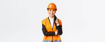 成功的自信微笑亚洲女架构师指出手指相机穿安全头盔反光夹克介绍建设项目工业女人邀请客户