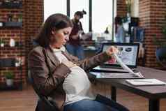 怀孕了女人质疑数据图表业务分析结果坐着办公室桌子上