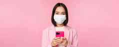 业务人科维德概念日本企业办公室夫人西装医疗脸面具移动电话微笑相机粉红色的背景