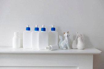 白色瓶蓝色的自动售货机洗发水护发素奶油液体肥皂雕像站架子上浴室的地方文本