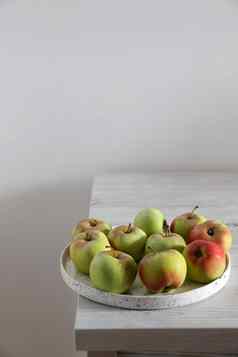 绿色红色的苹果白色陶器碗边缘米色厨房表格斯堪的那维亚风格极简主义的地方文本