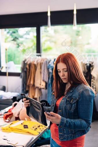 年轻的红发女人价格标签衣服买时尚商店购物概念休闲概念