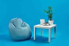 绿松石扶手椅豆袋白色咖啡表格绿色花能蜡烛照片框架蓝色的工作室背景复制空间