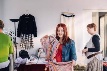 年轻的女人测试衣服前面镜子红发女孩购物时尚商店焦点运<strong>动效</strong>果