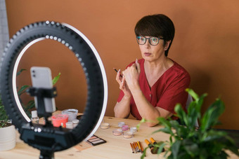 中年女美博主影响者化妆产品记录视频房间首页环灯智能手机
