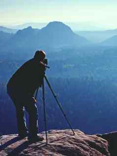 旅游指南照片爱好者保持三脚架悬崖思考梦幻多雾景观蓝色的有雾的日出美丽的谷