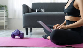 关闭亚洲女人移动PC电脑瑜伽工作室健身技术健康的生活方式概念