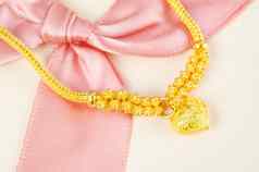 黄金手镯粉红色的丝带礼物概念