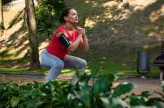 确定运动员女运动员锻炼户外深下蹲城市公园体育运动健身功能身体重量培训概念