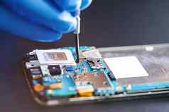 亚洲技术员修复微电路主要董事会智能手机电子技术电脑硬件移动电话升级清洁概念