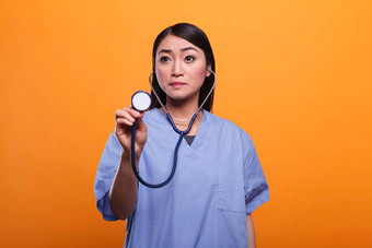 有关亚洲护士听诊器咨询生病的病人橙色背景
