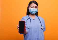 自信医院护士穿口罩听诊器指出智能手机相机