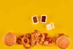 快食物菜前视图肉汉堡土豆芯片楔形作文法国薯条汉堡蛋黄酱番茄酱酱汁黄色的背景