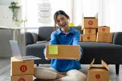 年轻的亚洲女人持有包裹盒子交付客户物流服务小业务企业家锻造分布仓库小老板首页办公室在线市场营销产品主题
