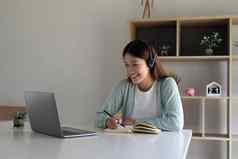 年轻的亚洲女人写作使列表采取笔记记事本工作学习移动PC在室内教育培训研讨会教育在线概念