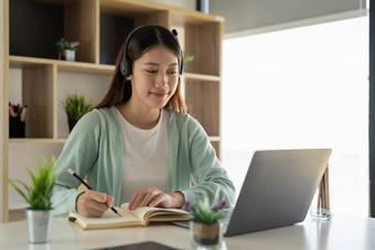 年轻的亚洲女人写作使列表采取笔记记事本工作学习移动PC在室内教育培训研讨会教育在线概念