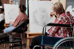 高级女人轮椅参加艺术类康复中心画花瓶草图