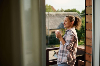 女人饮料咖啡欣赏农村风景阳台国家房子阳光明媚的一天