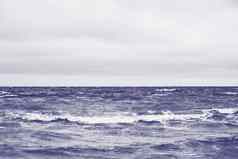 经典蓝色的海海滩北海狂风暴雨的天气强大的波悲观的天空海泡沫经典蓝色的颜色海的地方写作复制空间