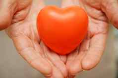 手持有红色的心医疗保健爱器官捐赠正念幸福家庭保险企业社会责任概念世界心一天世界健康一天国家器官捐赠一天