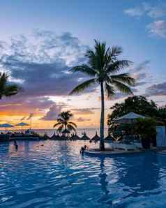 日落游泳池热带棕榈树奢侈品假期假期