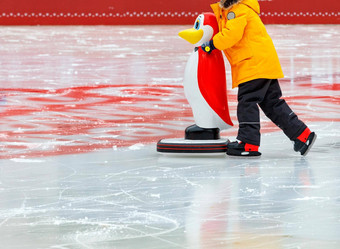 少年学习滑冰冰溜冰场持有助理<strong>玩具企鹅</strong>