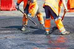 团队工人橙色工作服铲子水平沥青层修复部分路