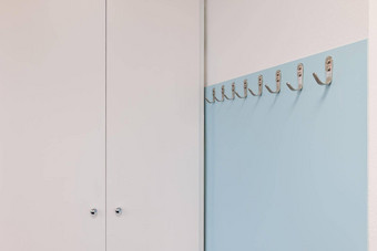 金属钩子光蓝色的墙白色衣柜现代办公室极简主义风格设计