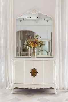 古董镜子花花束木橱柜恢复家具经典明亮的室内白色墙窗帘