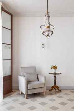 生活房间室内舒适的扶手椅一边表格白色墙复古的风格古董吊灯