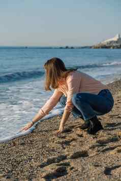 年轻的女人触碰波手海海滩