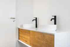 白色平铺的浴室洗盆地黑色的水龙头木橱柜