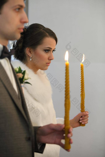 新娘新郎站婚礼仪式快乐时尚的婚礼夫妇持有蜡烛光金冠神圣的婚姻教堂