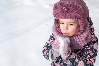 冬天游戏家庭童年概念特写镜头肖像真实的学前教育小年女孩粉红色的他温暖的衣服有趣的微笑雪冷淡的天气有趣的孩子吃味道雪
