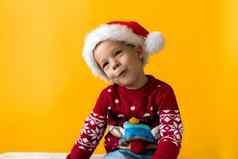 肖像快乐微笑积极的快乐的积极的学前教育男孩红色的温暖的圣诞老人他显示拇指橙色黄色的背景冬天假期庆祝活动圣诞节一年复制空间