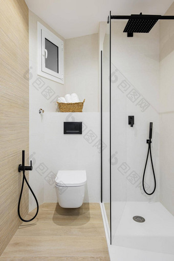 室内<strong>现代风格浴室</strong>白色米色颜色翻新公寓淋浴区厕所。。。黑色的水龙头毛巾平铺的地板上墙