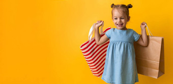 横幅肖像高加索人美丽的快<strong>乐学</strong>前教育女孩微笑快乐的持有纸板袋孤立的橙色黄色的背景幸福消费主义出售人购物概念