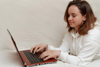 女孩白色连帽衫持有移动PC打字电脑免费的空间有趣的工作研究了<strong>首页</strong>科维德保持<strong>首页</strong>工作<strong>首页</strong>