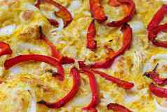 特写镜头披萨超过红色的胡椒洋葱黄色的咖喱酱汁宏拍摄美味的产品