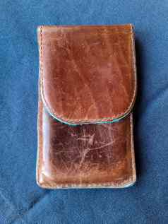 棕色（的）手工制作的皮革情况下智能手机蓝色的背景
