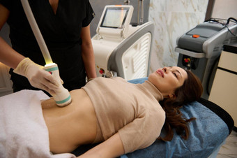 迷人的女人接收瘦身减肥治疗水疗中心沙龙超声波空化身体轮廓线治疗