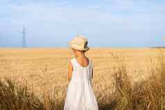 女孩站黄色的小麦场穿着白色衣服稻草他