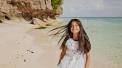 迷人的快乐菲律宾十几岁的女孩白色夏天衣服运行热带海滩岩石幸福的旋转童年娱乐