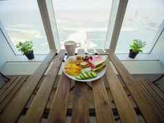 光早餐炒鸡蛋水果背景摩天大楼窗口棕榈朱美拉迪拜