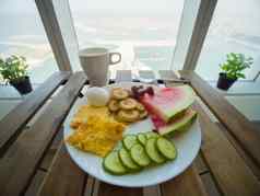 光早餐炒鸡蛋水果背景摩天大楼窗口棕榈朱美拉迪拜