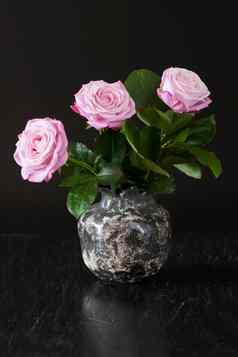 花束粉红色的玫瑰黑色的花瓶黑色的木背景