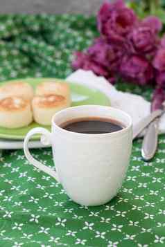 黑色的咖啡白色复杂的杯美味的饮食奶酪蛋糕自制的农民奶酪早餐花束紫色的郁金香绿色桌布