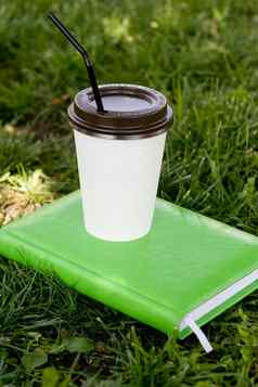 白色纸杯黑色的热咖啡茶酒吧站绿色笔记本