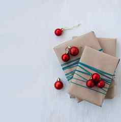礼物包装工艺纸明亮的红色的圣诞节球形式球礼物重绕蓝色的线程礼物谎言白色木背景的地方问候文本