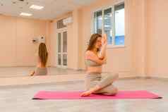 年轻的运动女人健身教练运动服装伸展运动普拉提瑜伽席工作室镜子女健身瑜伽例程概念健康的生活方式和谐